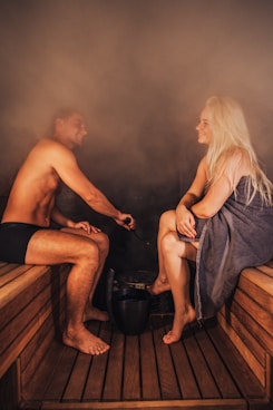 A man and woman relaxing in a sauna.