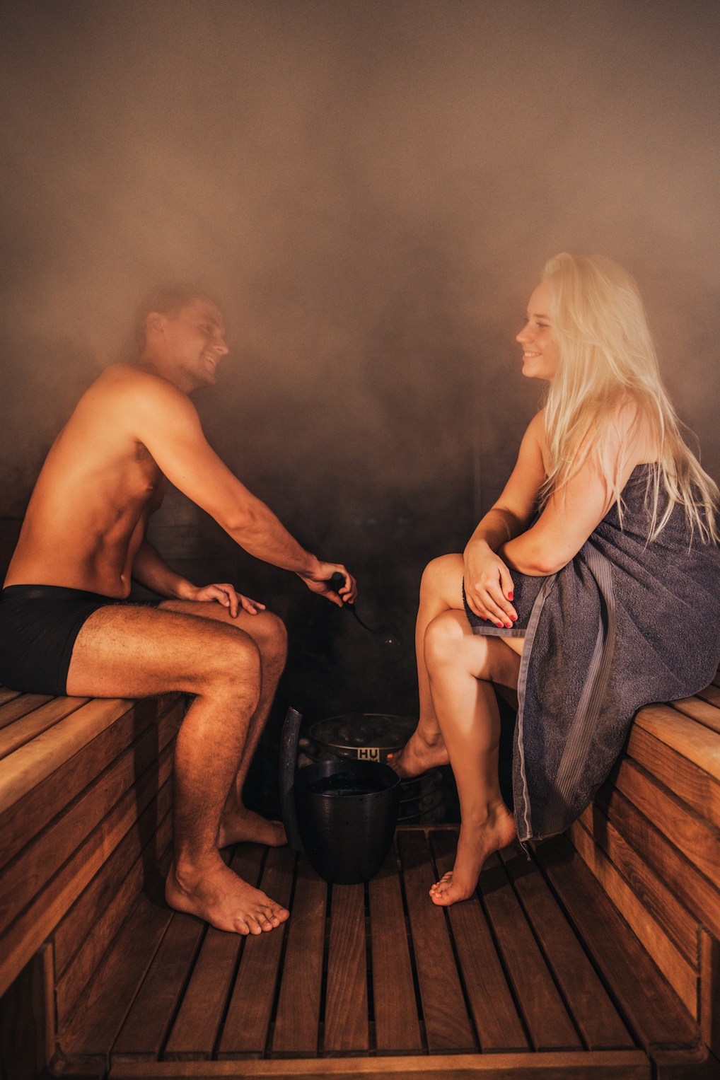 A man and woman relaxing in a sauna.