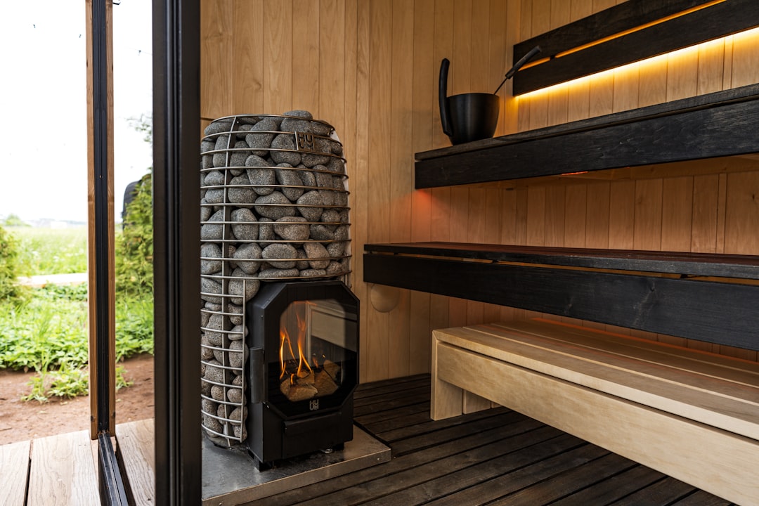 Cozy sauna interior, ready for relaxation., levate your sauna experience with the HIVE Flow—one of the greenest wood-burning stoves available. Its innovative design captures 75% of the heat from firewood, keeping your sauna warmer longer and minimizing wasted energy. The generous stone capacity (up to 150 kg plus an additional 35–40 kg in the stone cage) offers a soothing steam that lasts well after the fire is out. With CO emissions of 346 mg/m³ and just 25 mg/m³ of particulates, the HIVE Flow sets a new standard for clean and responsible sauna heating. The wide glass door adds an inviting view of the flames, and the robust constructio