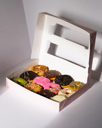 A box filled with assorted, colorful donuts.