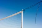 Volleyball net against a bright, blue sky.