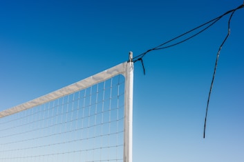 Volleyball net against a bright, blue sky.
