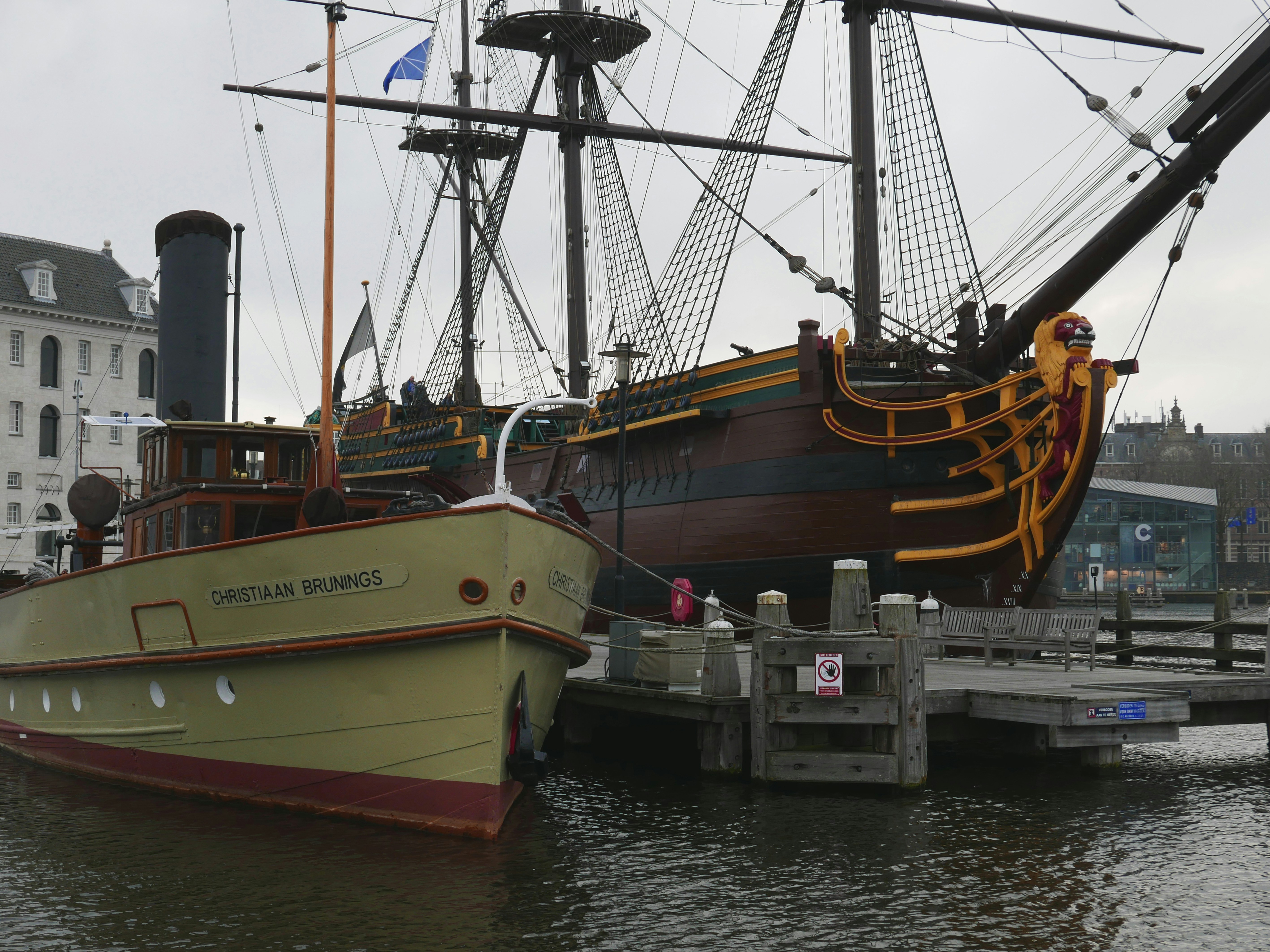 Free photo of historical old boats and ships are located behind the maritime Museum in Amsterdam city - right, a historical sailing ship in replica; right, an old steam boat. Photography of The Netherlands in free download images and high resolution // Foto van zeilschip De Amsterdam - een replica van een 17e eeuws V.O.C. schip, naast het Scheepvaartmuseum in Amsterdam; fotografie van Nederlands verleden in gratis download en hoge resolutie, door Fons Heijnsbroek