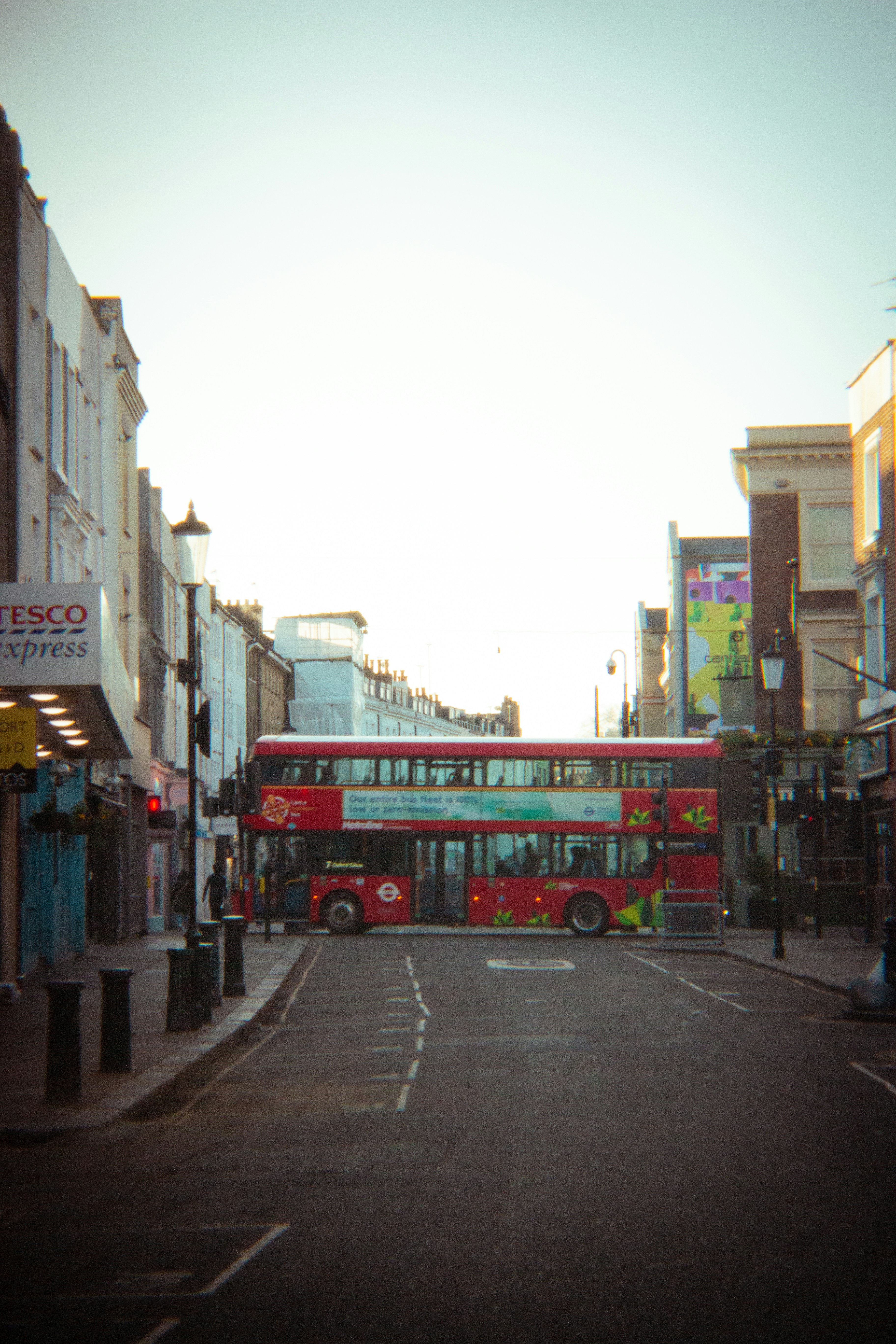 Um ônibus vermelho de dois andares em uma rua de Londres.