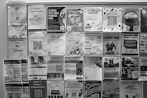 Bulletin board covered with many posters.