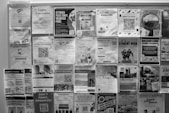 Bulletin board covered with many posters.