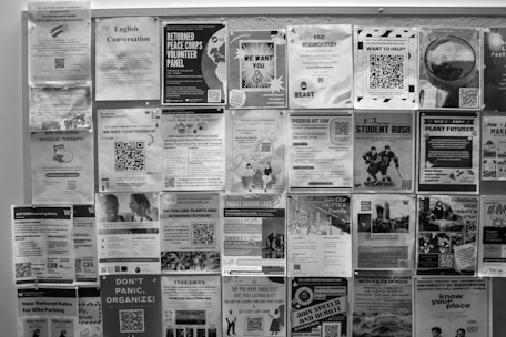 Bulletin board covered with many posters.