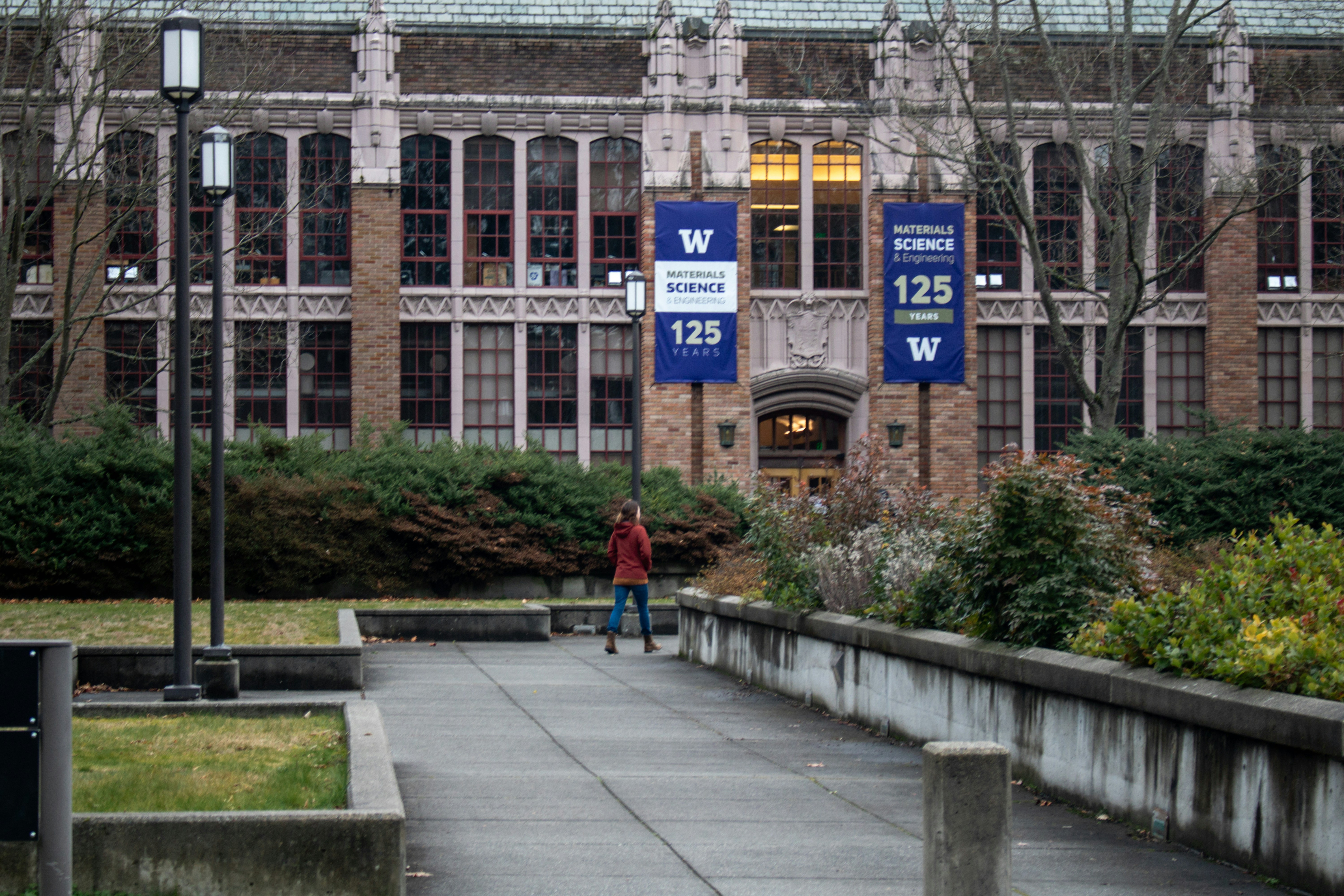 A person walks toward a university building.