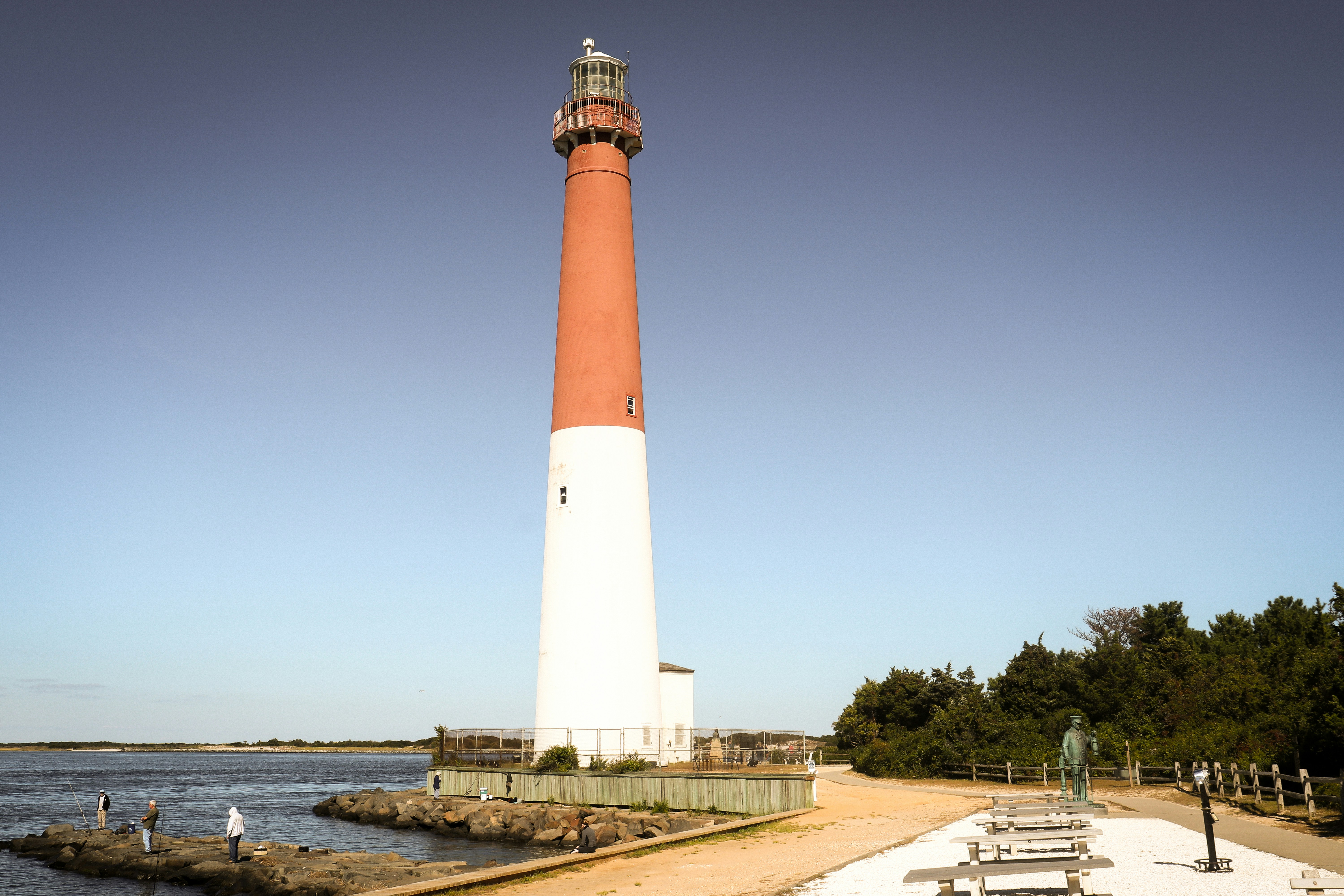 A tall lighthouse stands near the coast.