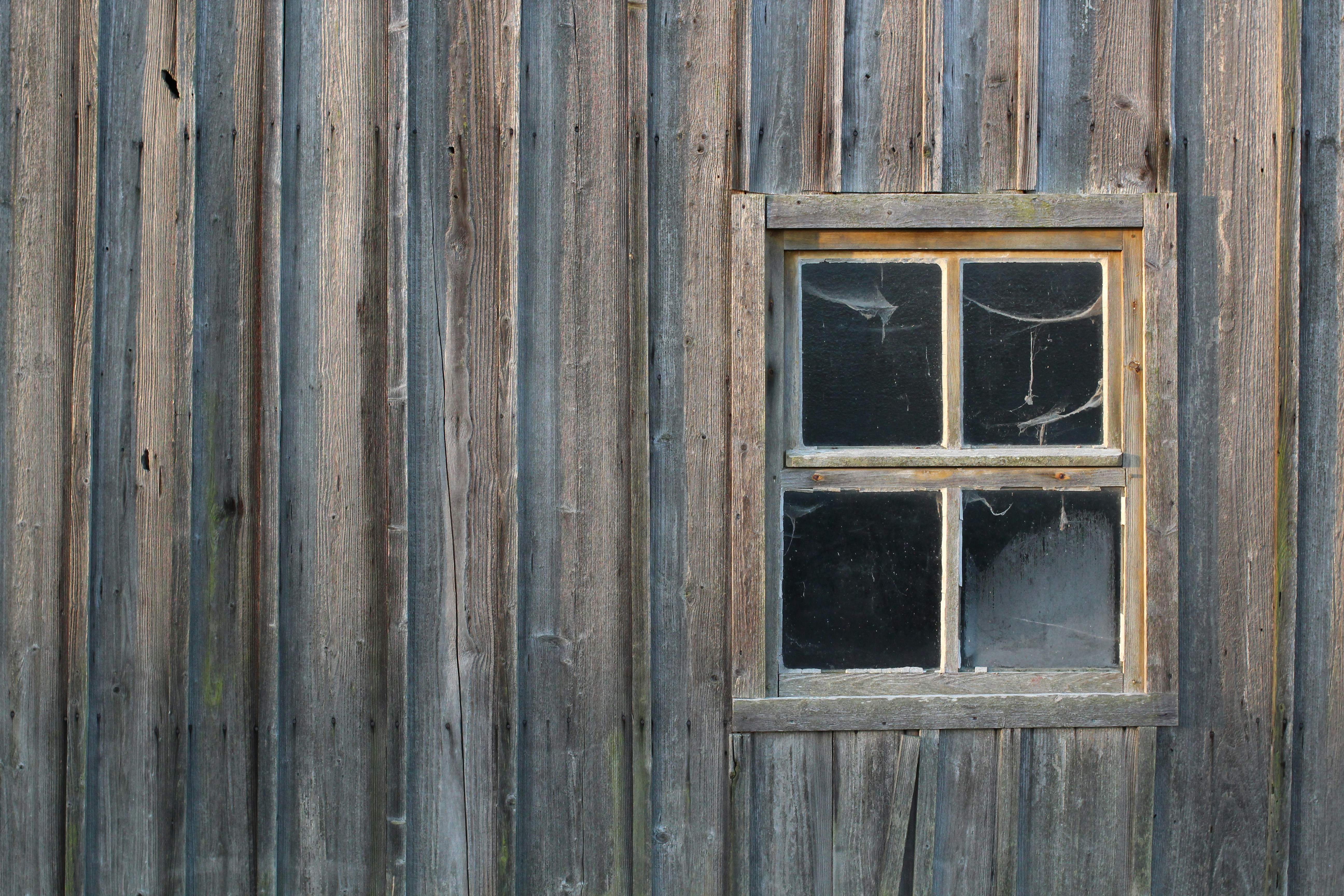 Rustic wooden wall with a small window.