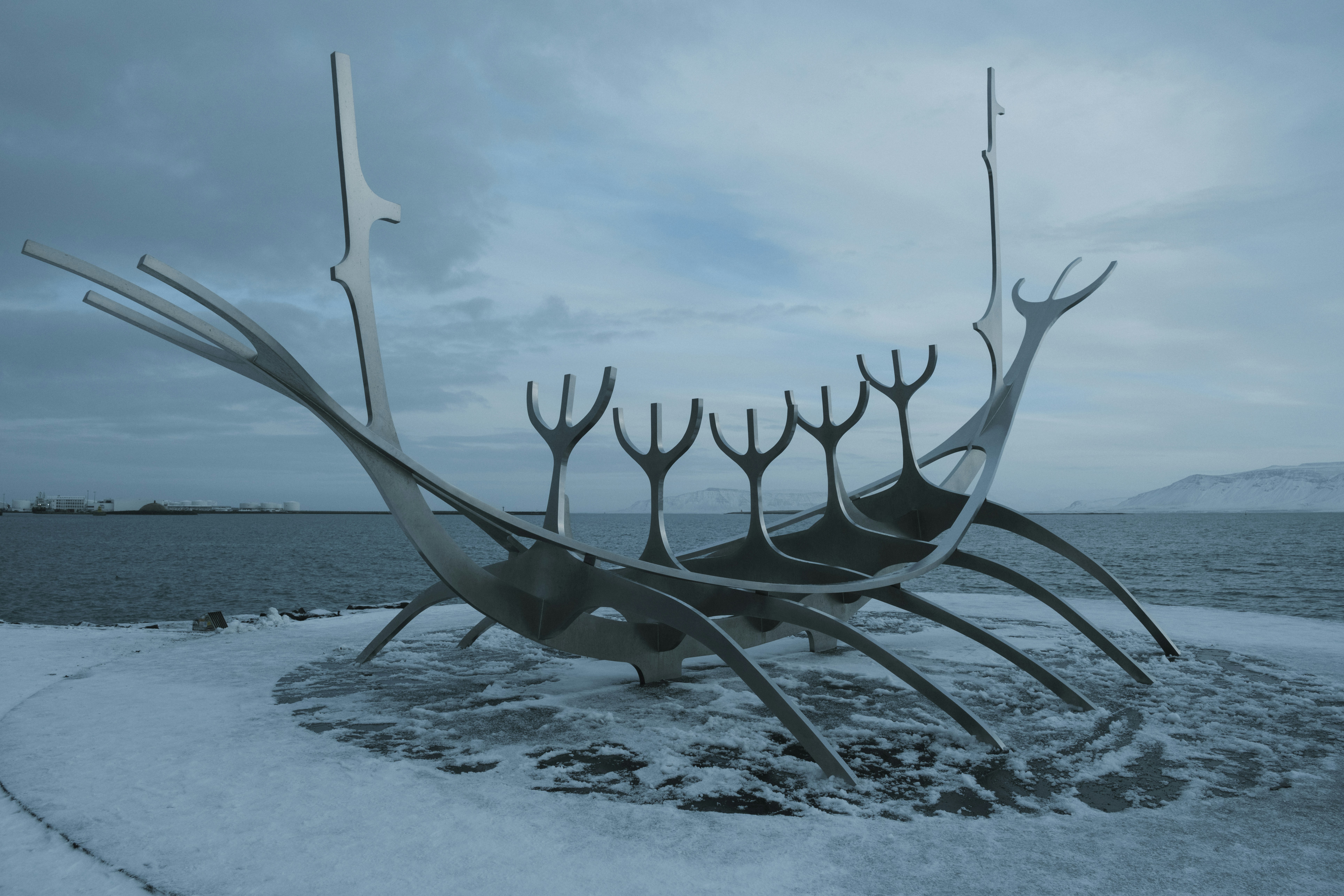 A boat sculpture sits on the shore.