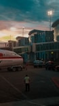 Airport scene at dusk, a plane parked.