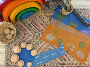 Wooden toys and colorful rugs are arranged creatively.