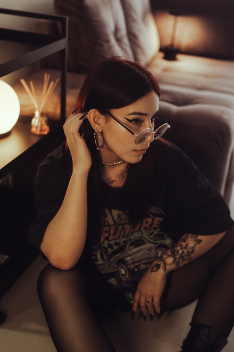 Woman poses thoughtfully in a dimly lit room.