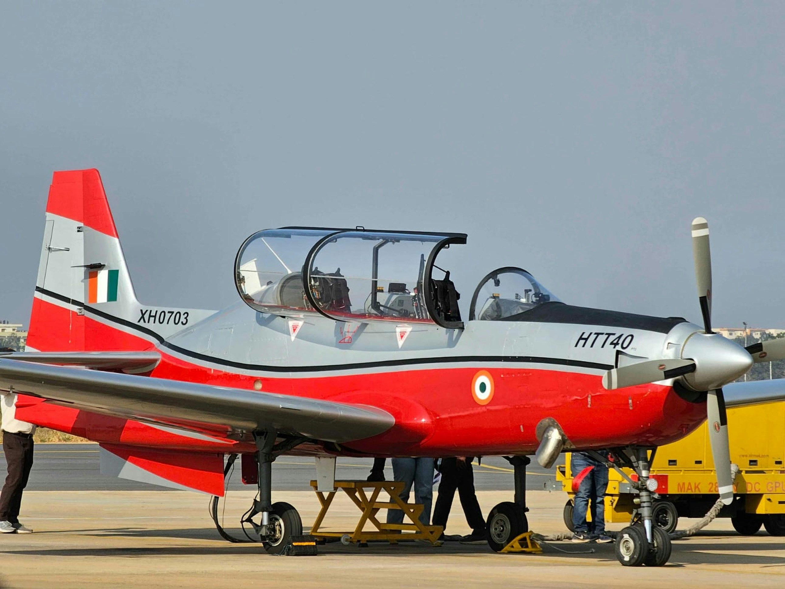 A red and silver airplane is on the ground.