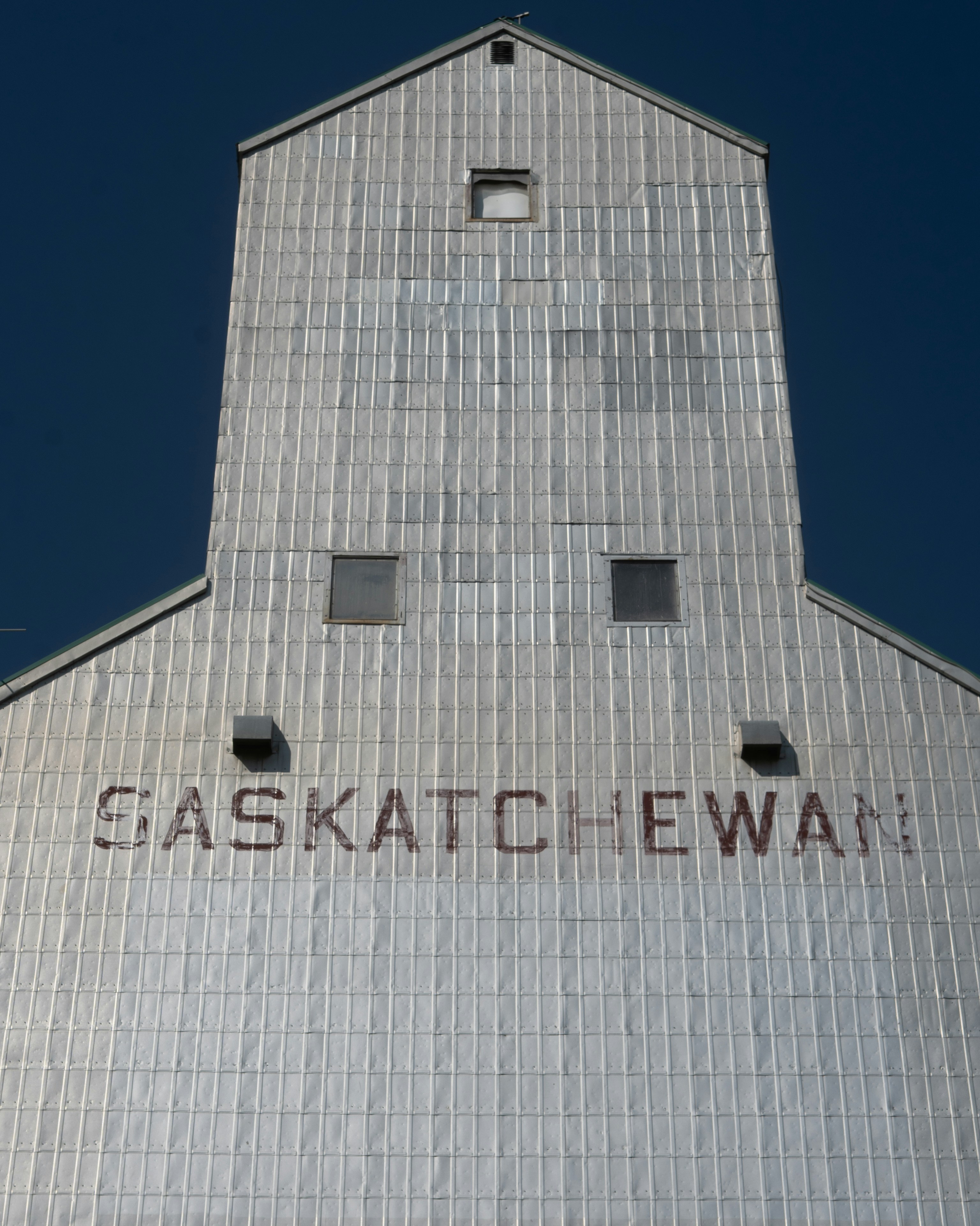 A saskatchewan grain elevator against a blue sky.