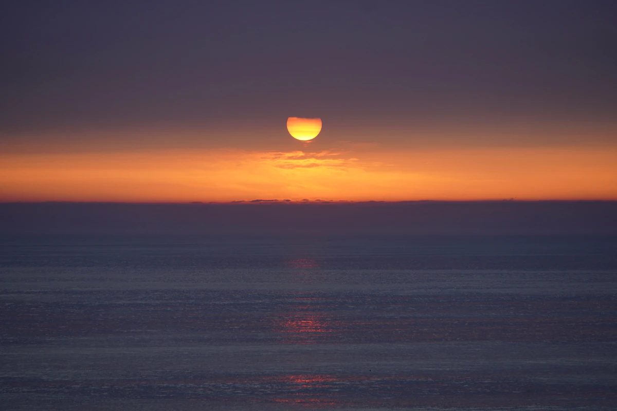 Sonnenuntergang über einem ruhigen Meer als Symbol für Ruhe und rauchfreie Gelassenheit