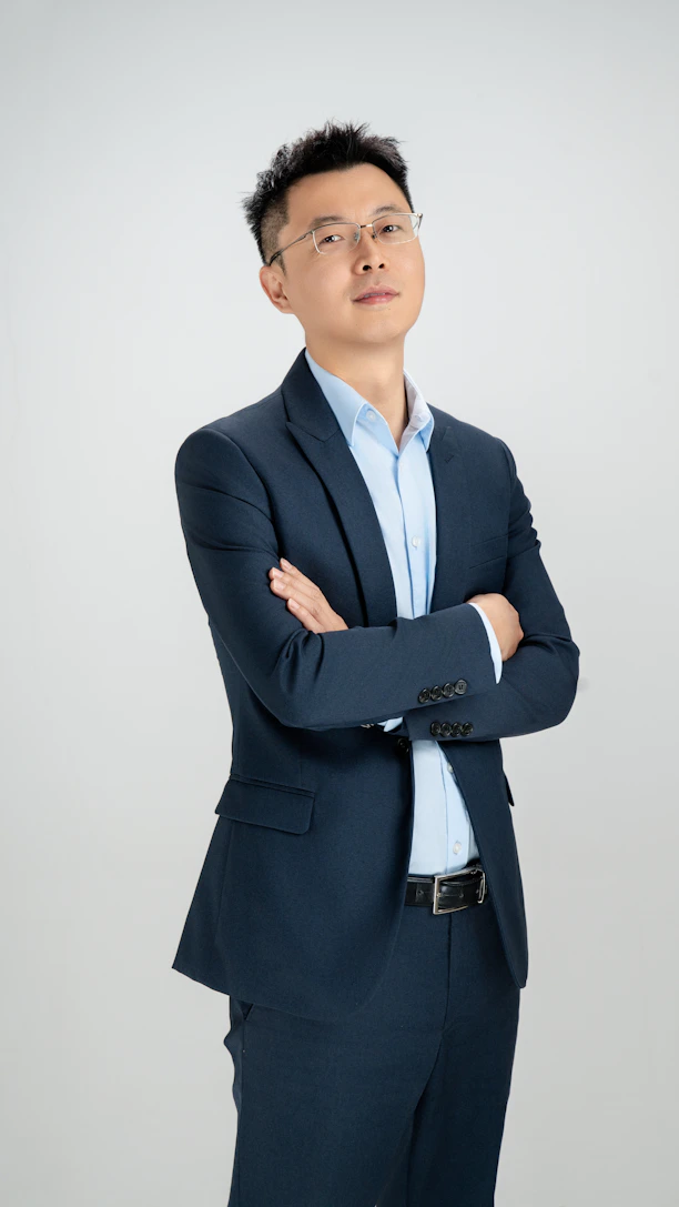 A man in a suit poses confidently.