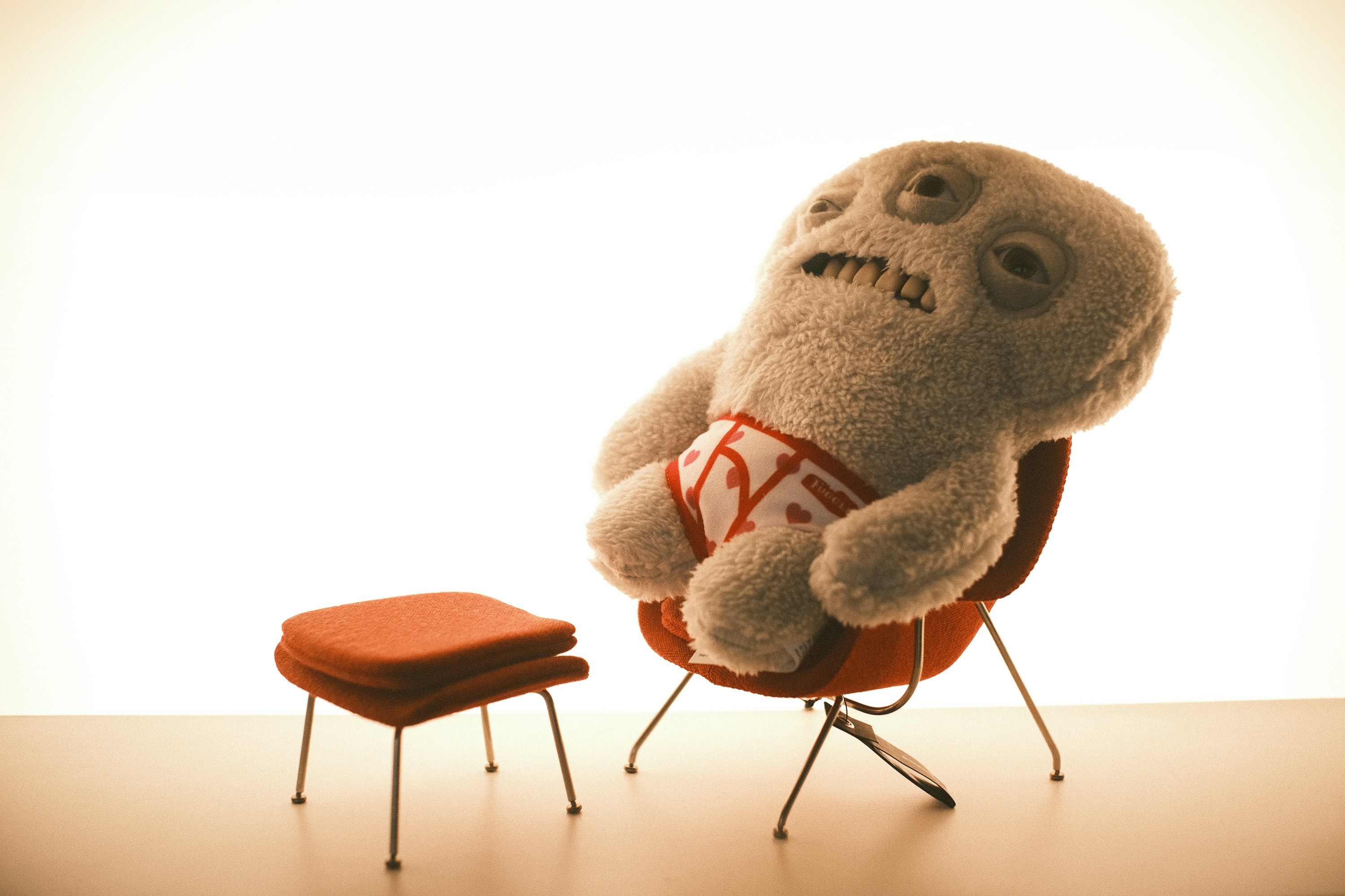 A fuzzy creature relaxes in a chair.