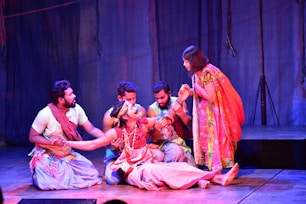 Actors perform a dramatic scene on a stage.