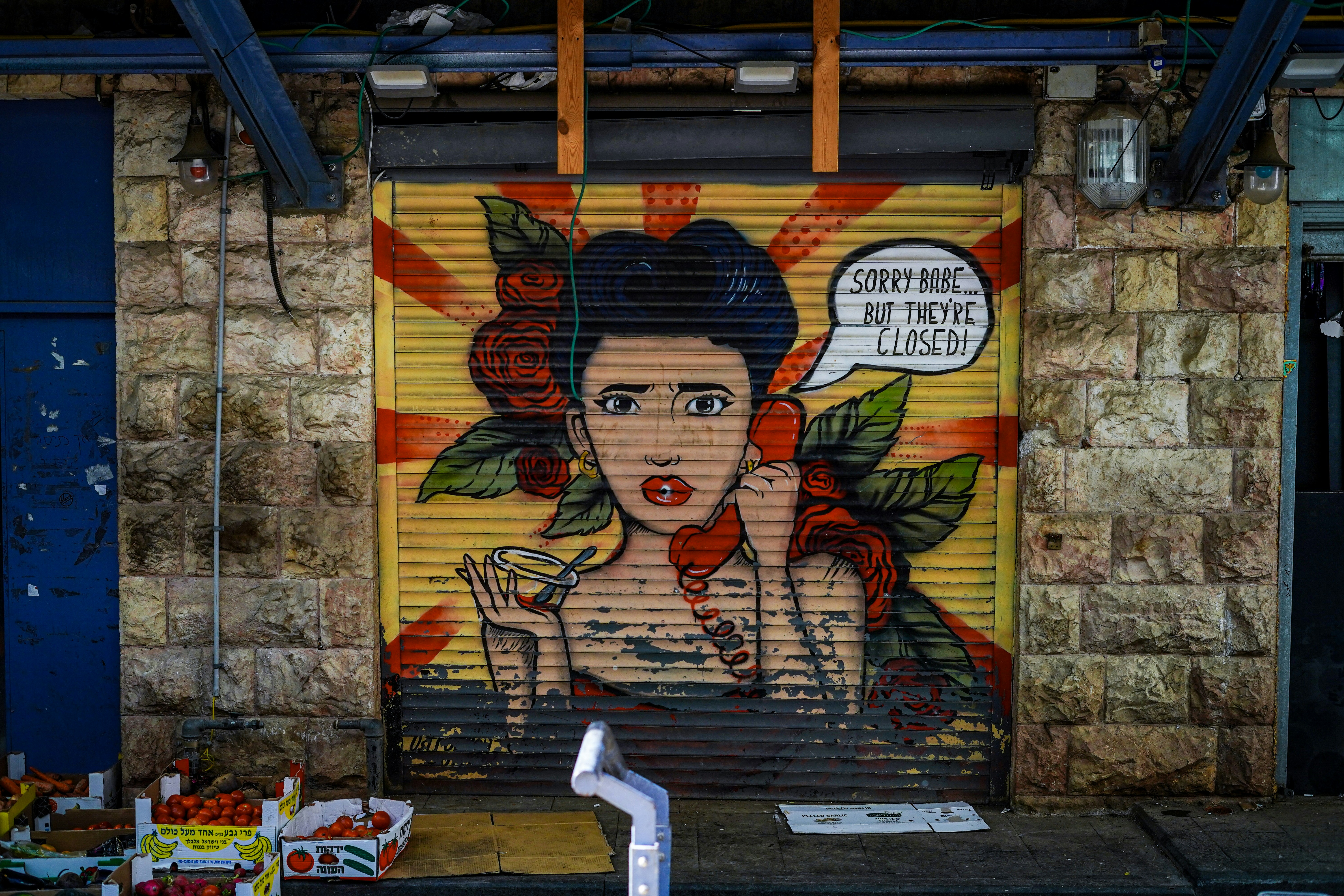 Graffiti art of a woman on a shuttered shop.