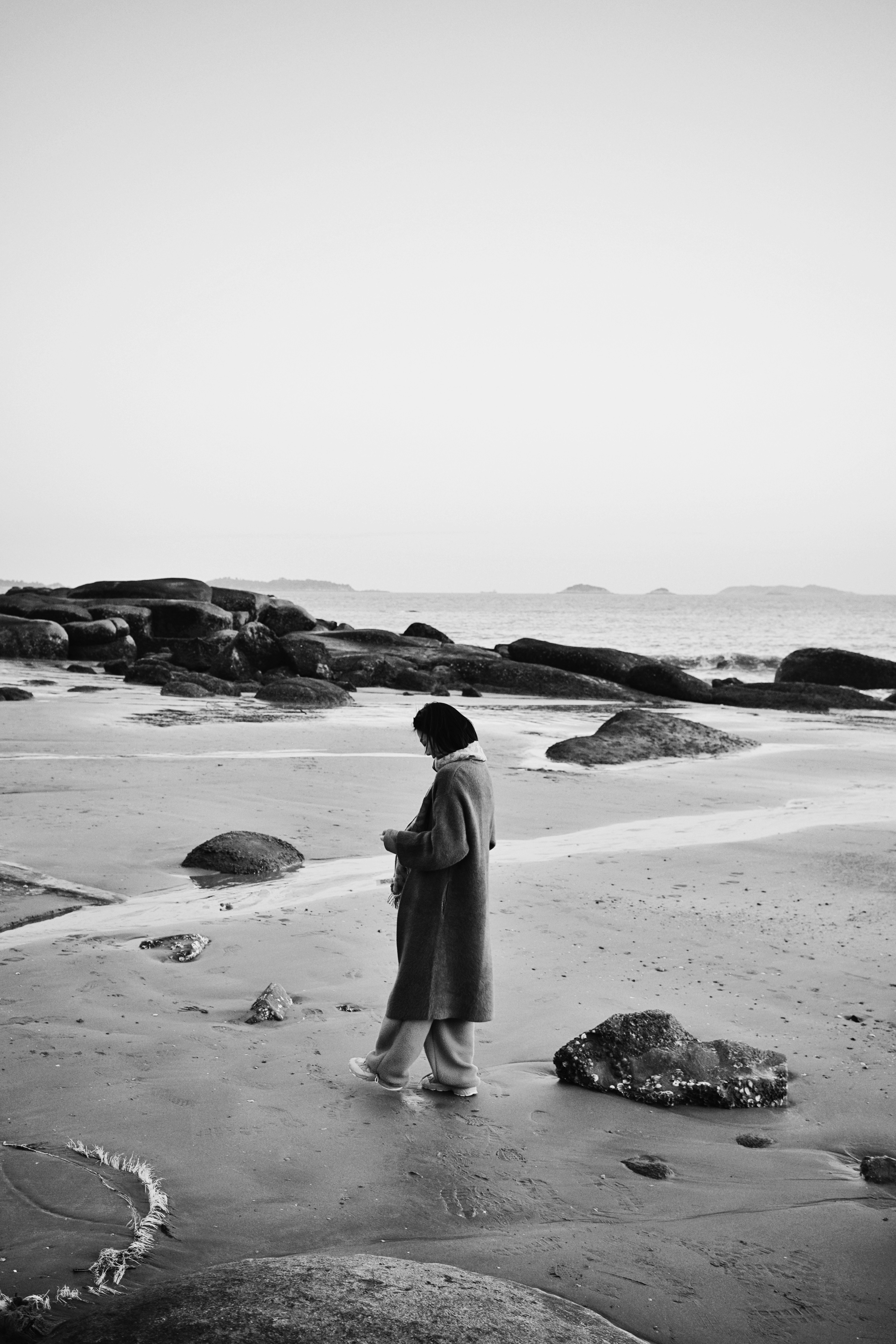 A person walks alone on the beach.