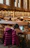 Students study in a library with bookshelves.