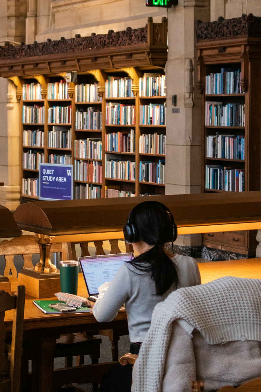 Student working at a laptop in a quiet library study area