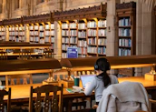 A student studies in a large, old library.