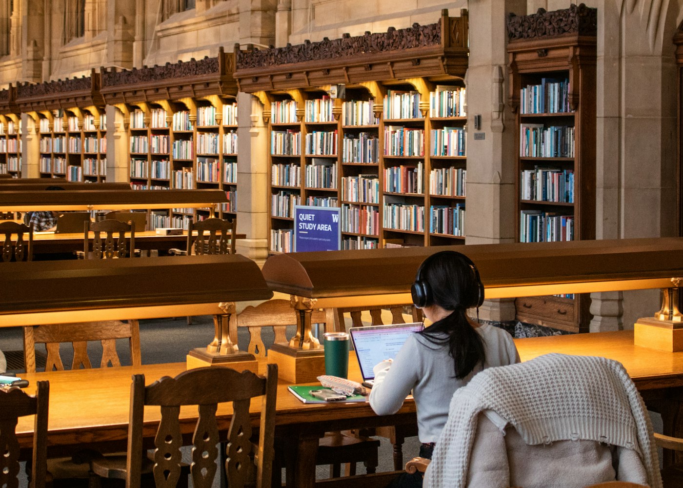 Student reading in a large old university library