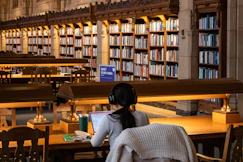 Student studies at a library with books