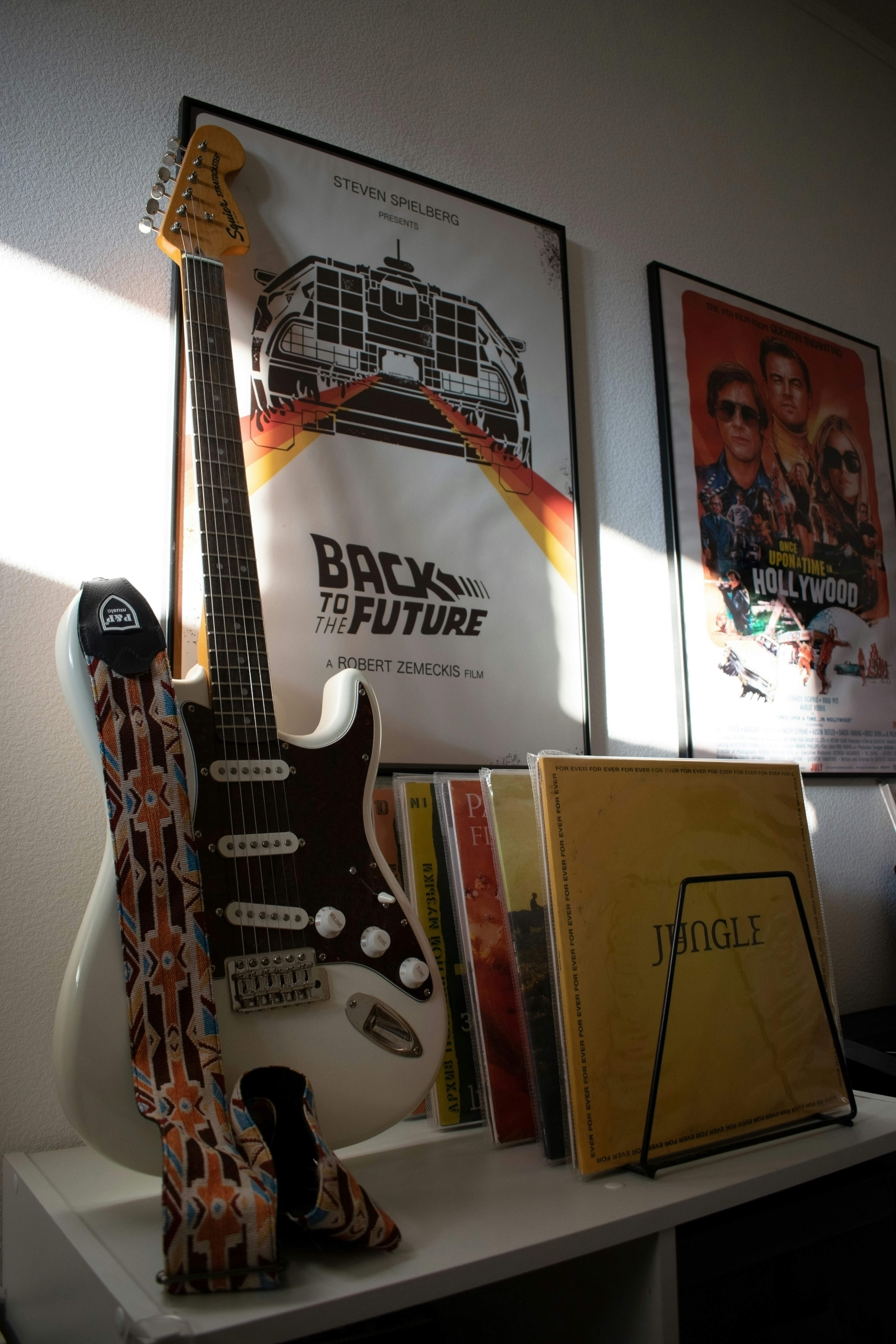 Guitar, albums, and movie posters on display.