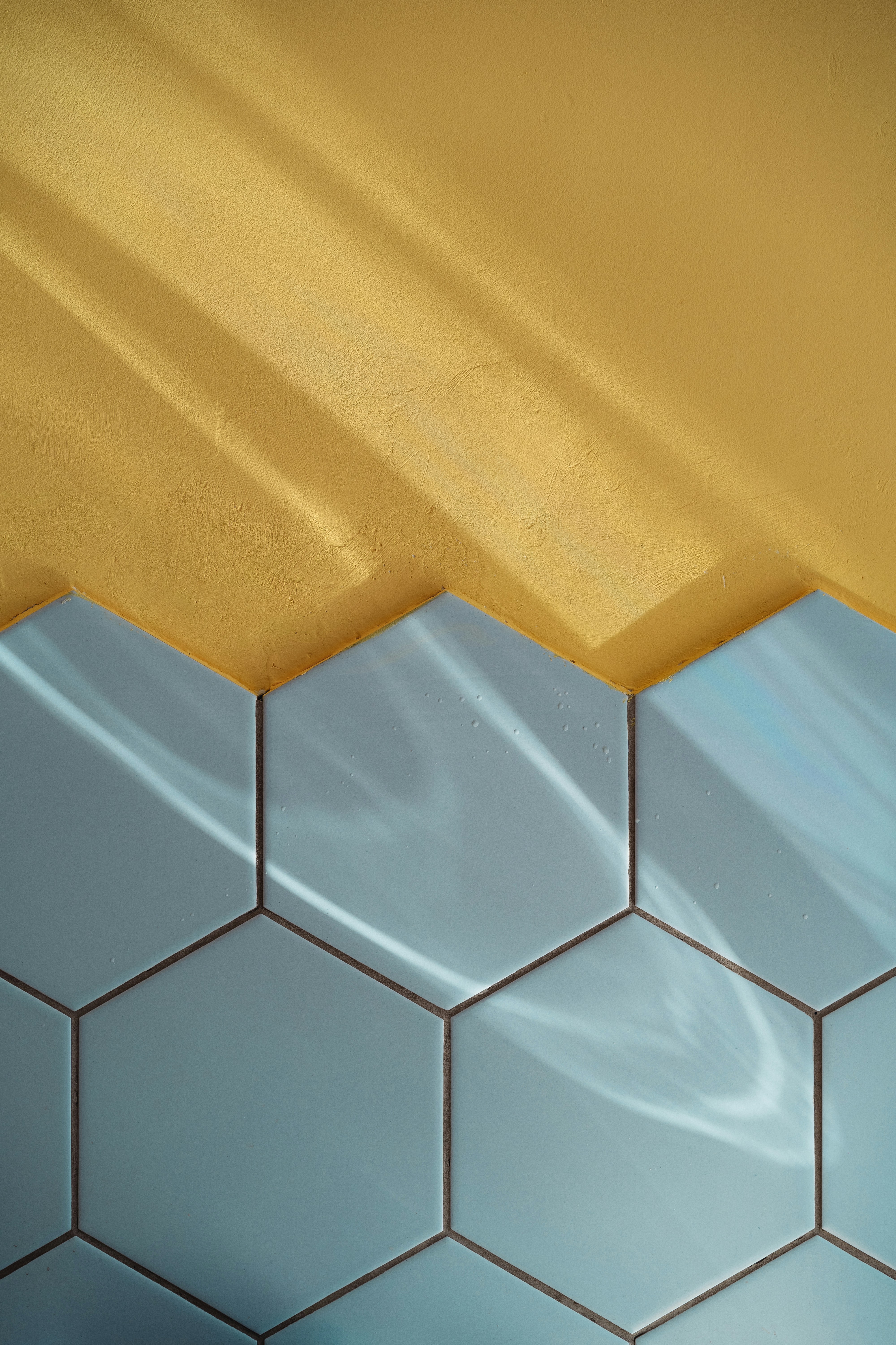 Blue tile and yellow wall with reflections.
