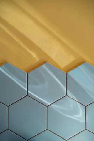 Blue tile and yellow wall with reflections.