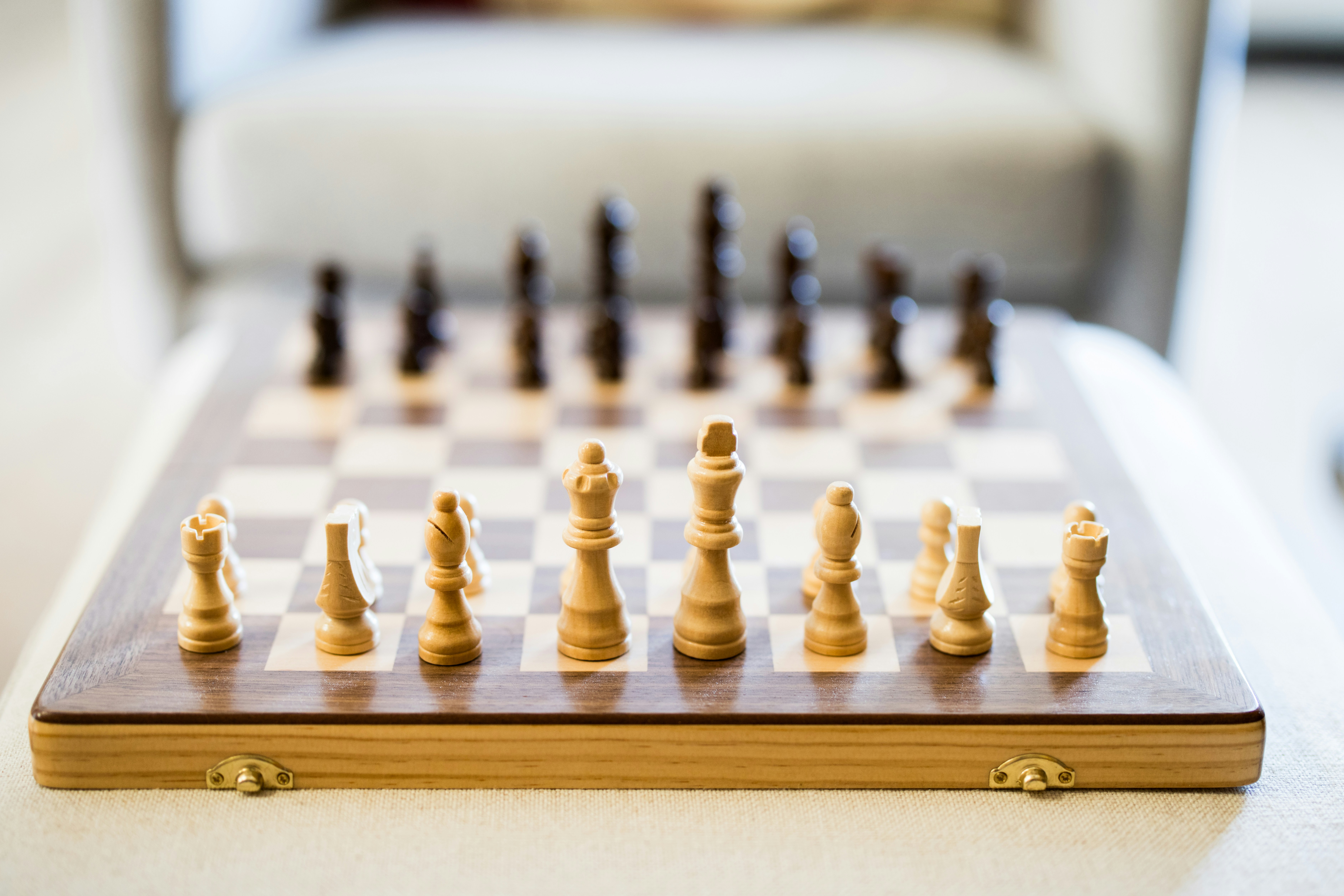 Schachbrett mit Schachfiguren, die für eine Partie aufgestellt sind.