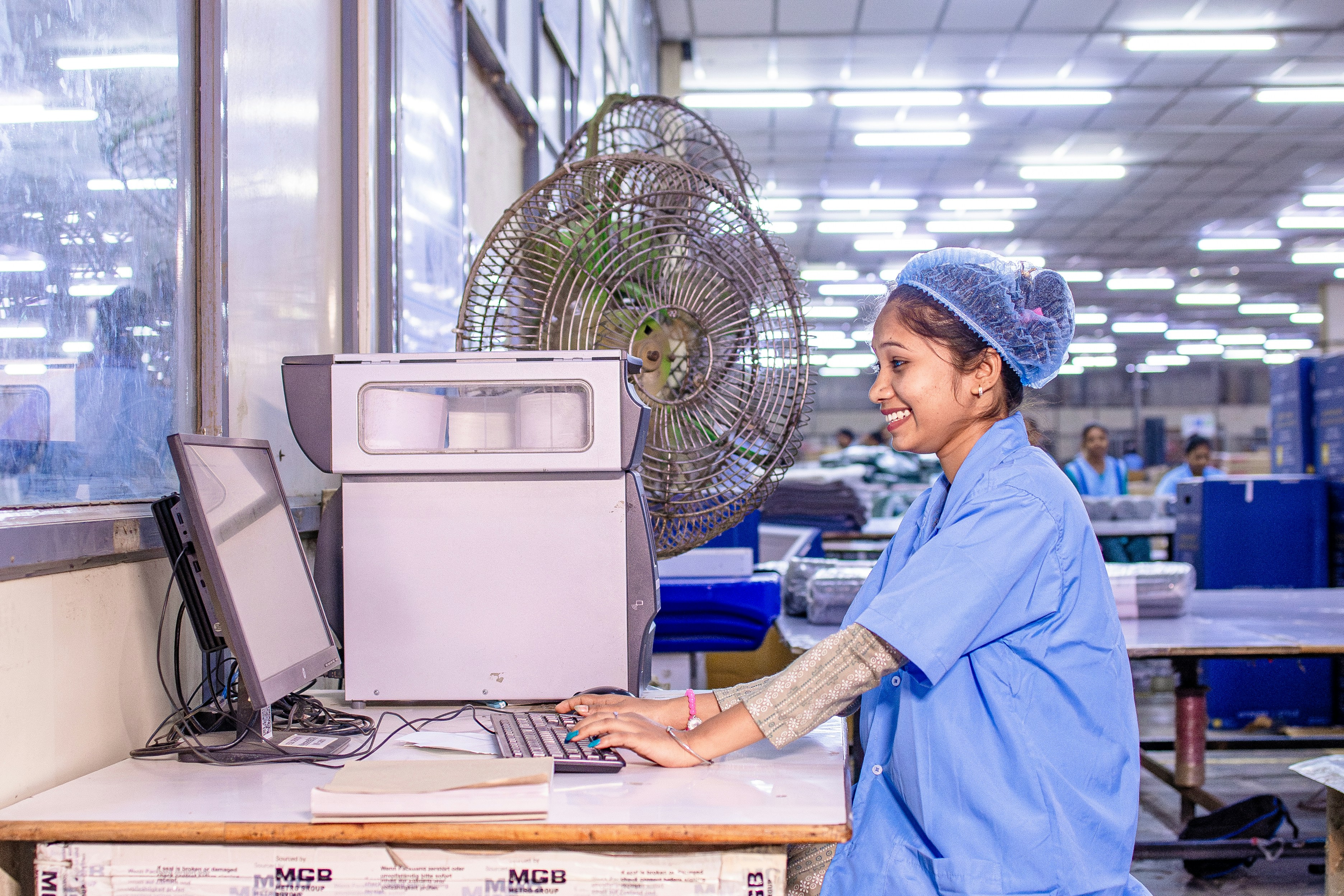 A smiling woman works at a computer.