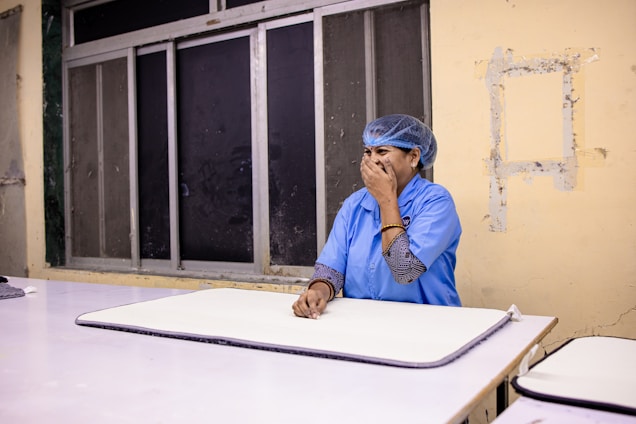 A woman wearing a hairnet sits at a table.