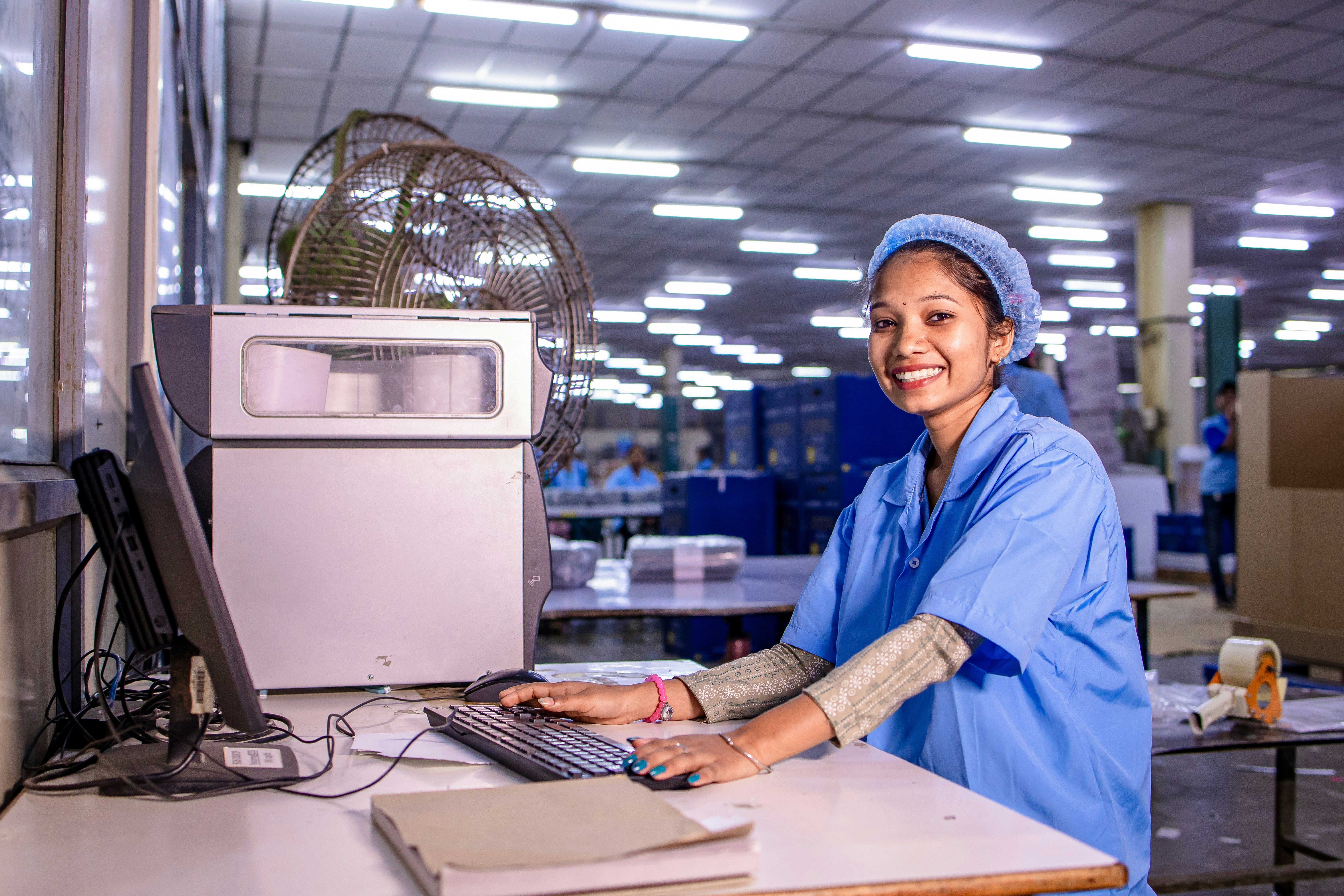 Une femme travaille à l’ordinateur dans une usine.