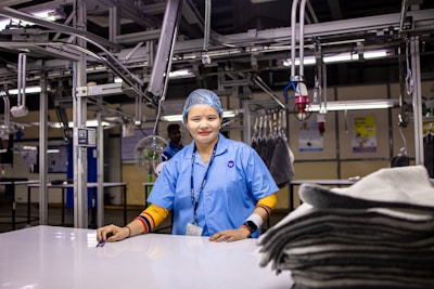 A smiling woman stands in a factory.