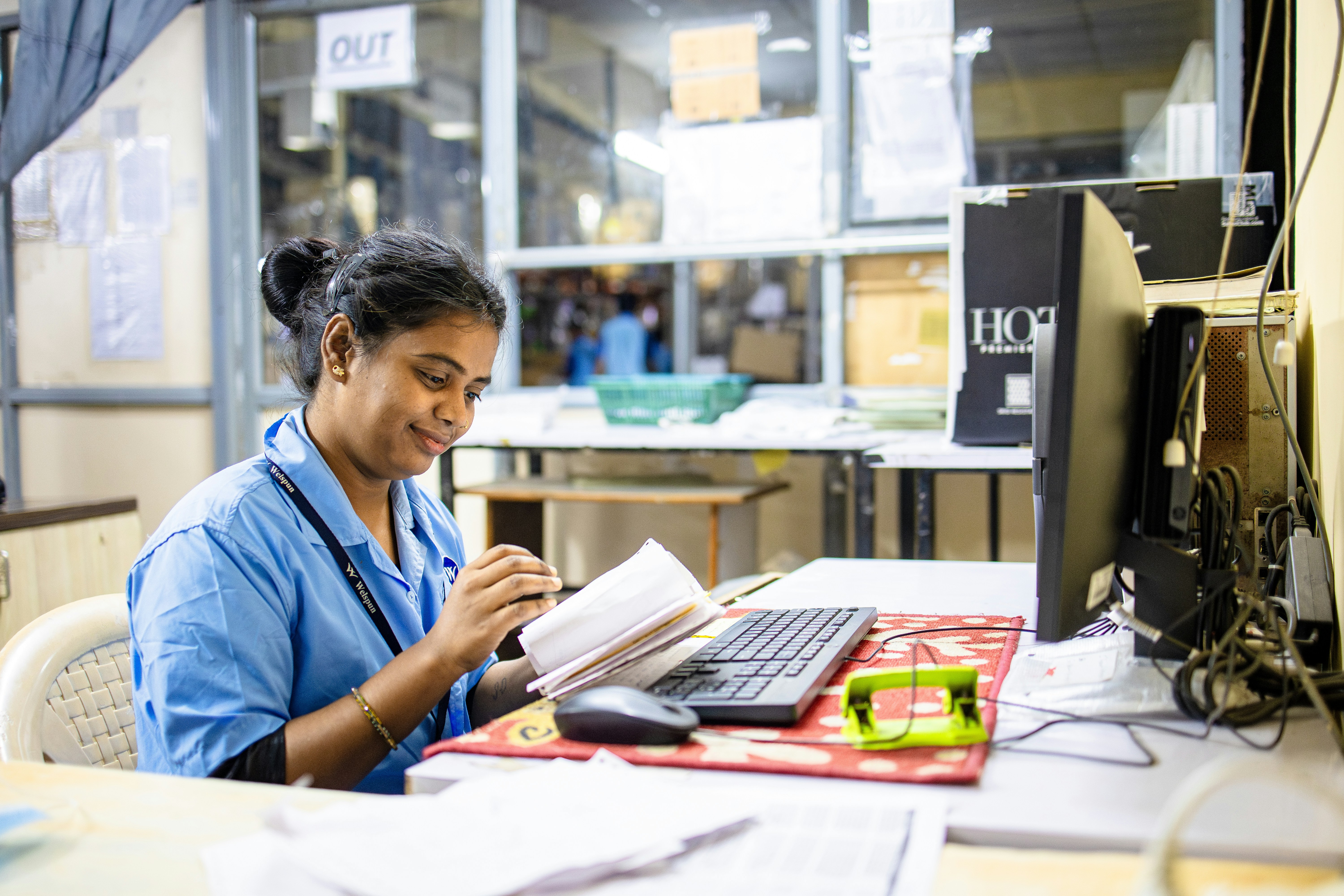 Woman working at a computer, smiling.