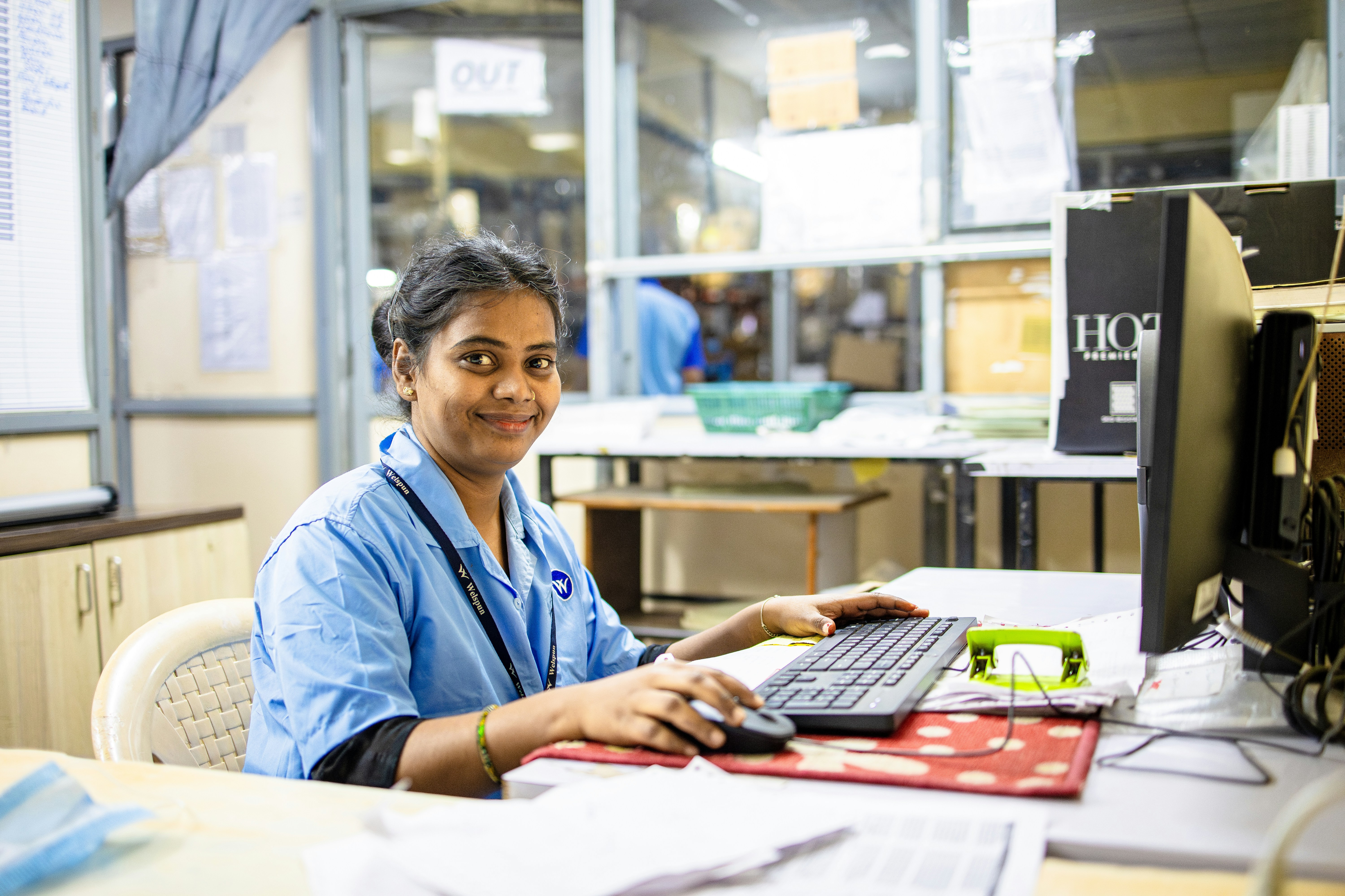 A woman works at her computer smiling.