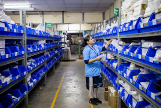 Woman sorts supplies in a warehouse.