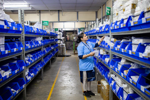 Woman sorts supplies in a warehouse.