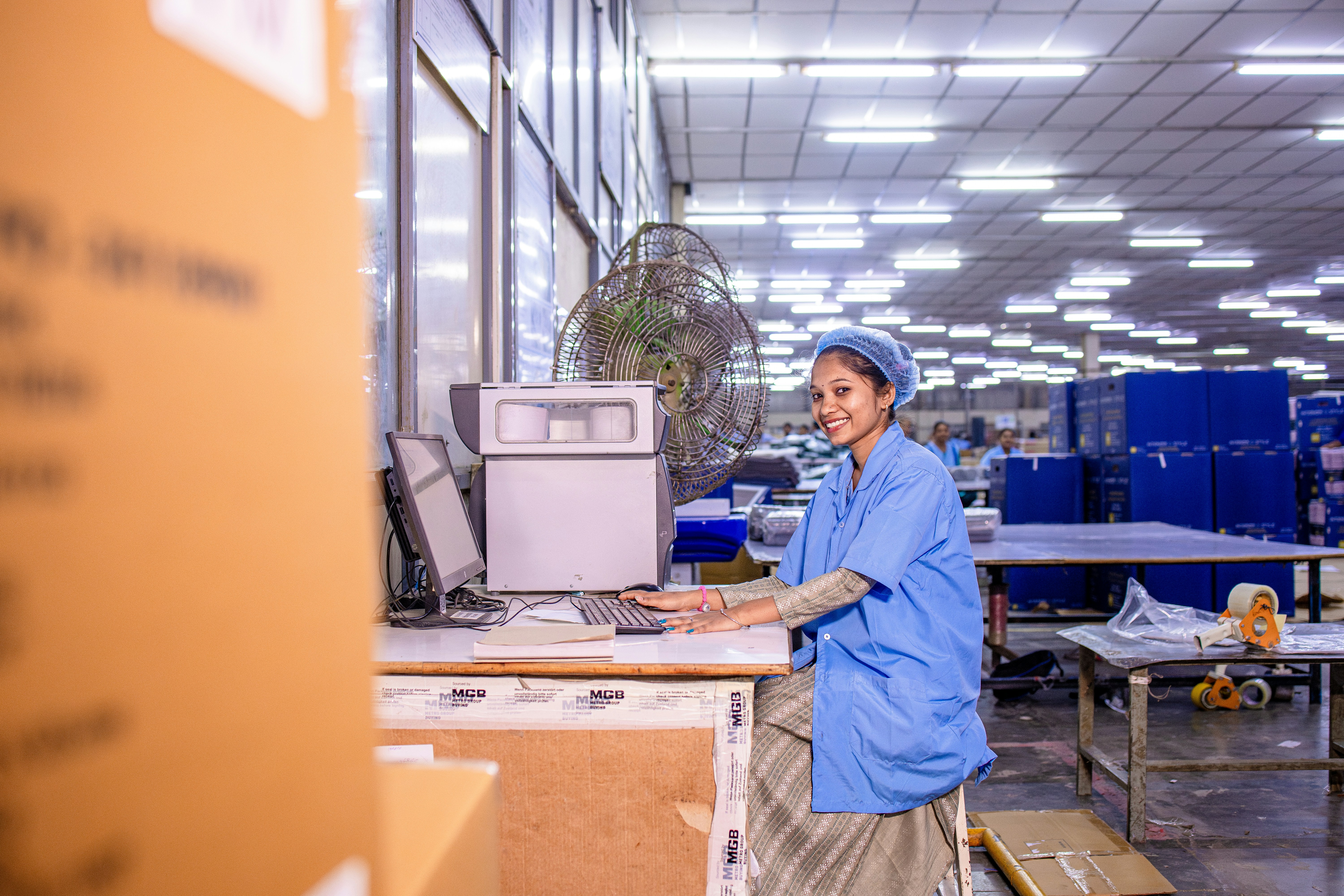 Woman working at a computer in a warehouse.