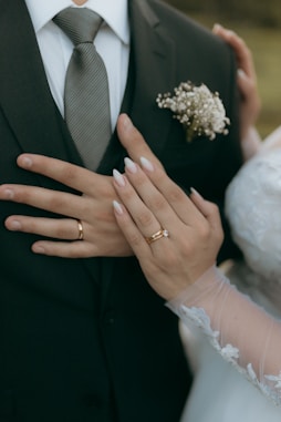 Bride and groom show off their wedding rings.