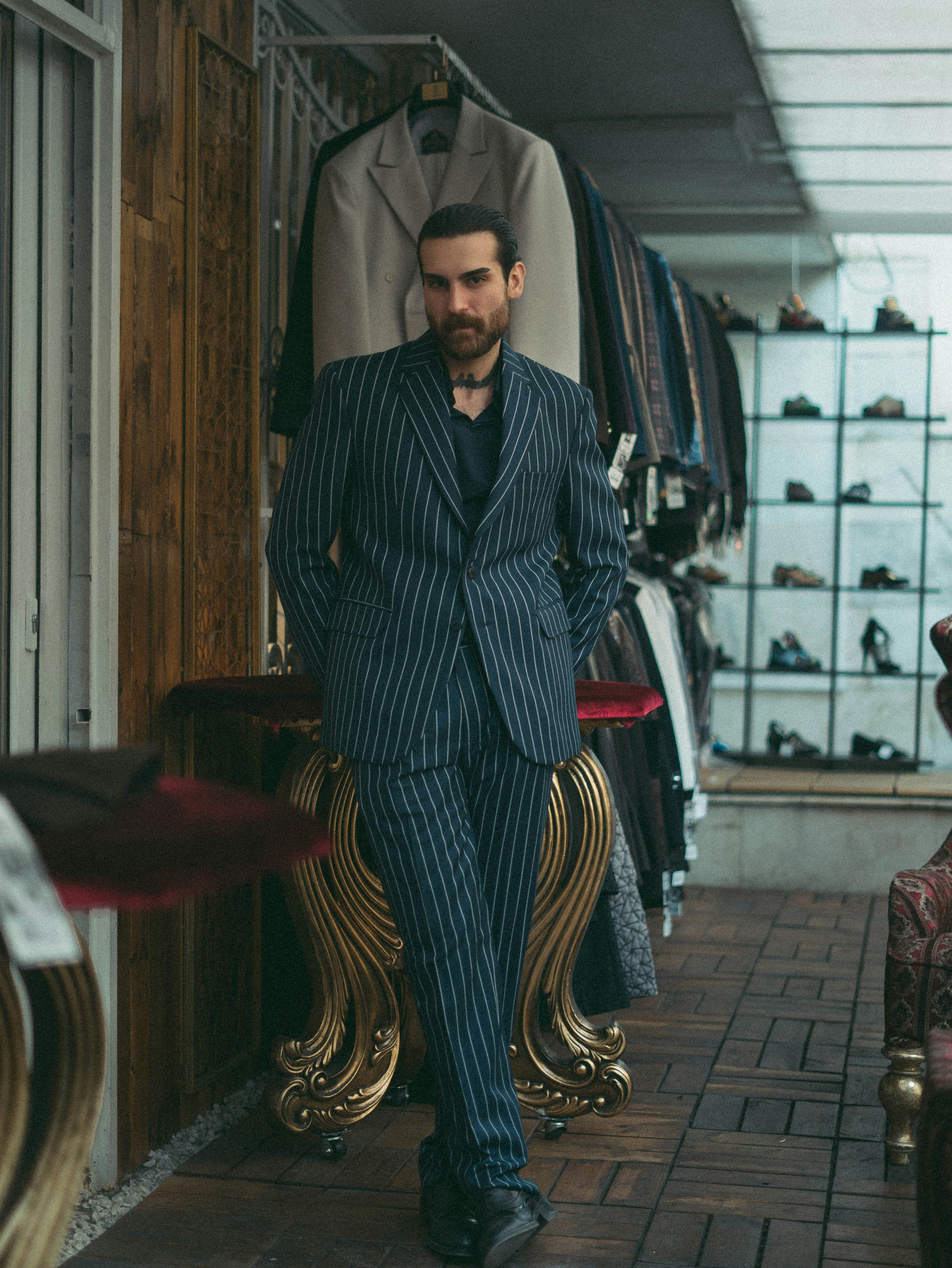 スーツ姿の男性が店内でポーズをとっています。