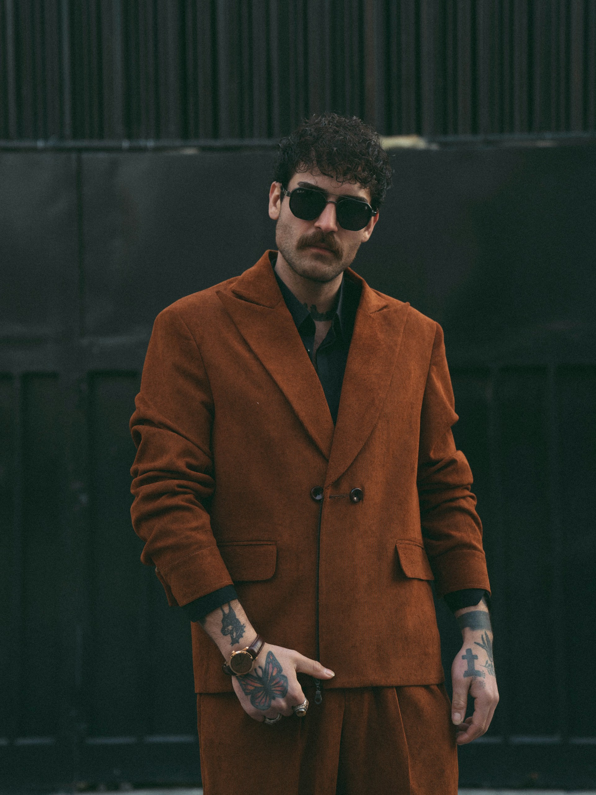 Stylish man poses in a brown suit.