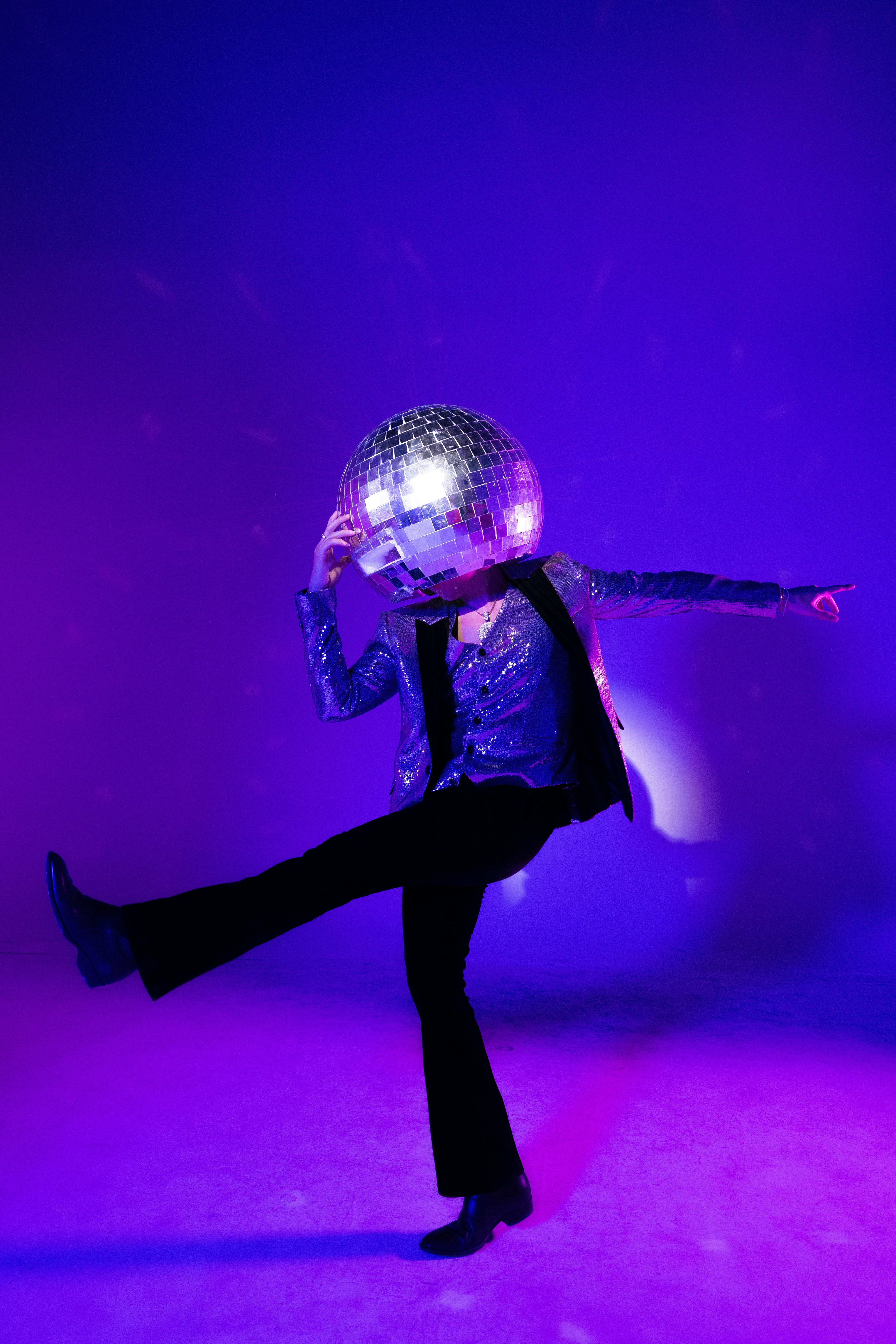 La personne danse avec une boule disco pour une tête.
