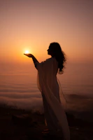 Woman holds the sun in her hand.