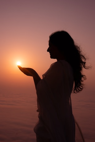 Woman holds the sun in her hands.